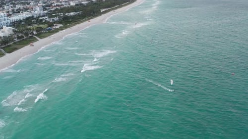 Kite Surfers Ride the Ocean Near Beach