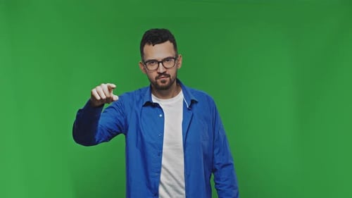 Positive Man Pointing Finger to Camera Isolated Over Green Background