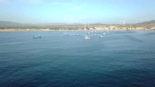 Aerial View of Small Village Shore with Colorful Fishing Boats on Turquoise Ocean.
