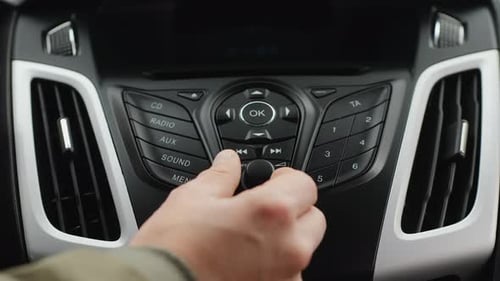Male Hand Adjust the Volume or the Tuning of the Car Radio