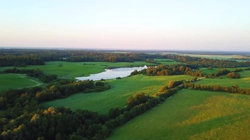 Aerial View of Green Fields and Lake at Sunset