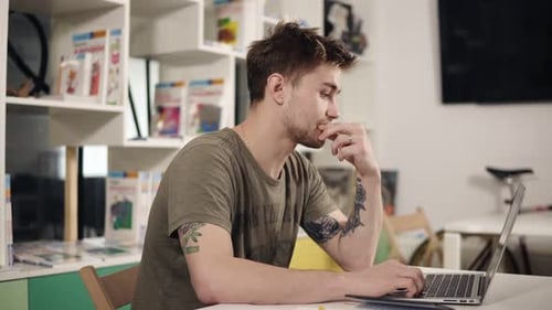 Man Working on Laptop Computer Indoors