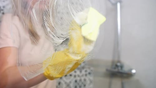 Mujer limpiando cabina de baño