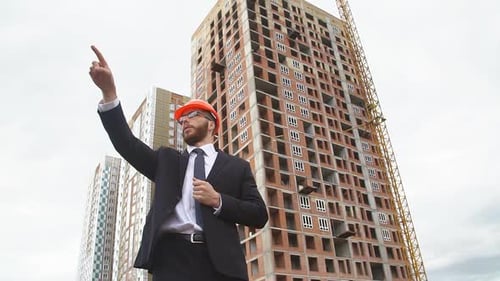 Man Points at Building Construction Site