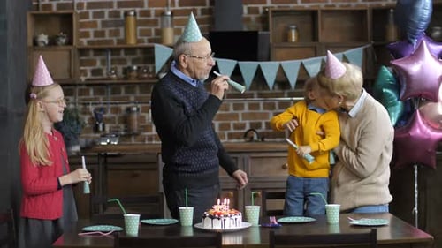Family Celebrates Birthday with Cake and Noisemakers