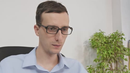 Closeup of the Office Employee in Glasses at Work