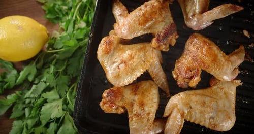 The Fried Wings in a Hot Frying Pan Rotate Slowly.