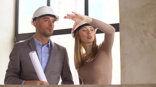 Architects with Blueprint and Helmets at Office 21