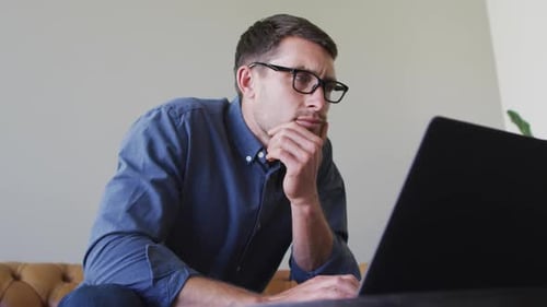 Focused Man Working at Laptop at Home