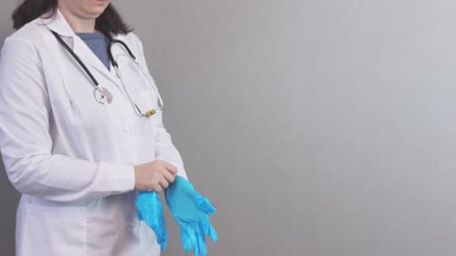 Health Professional Puts on Medical Gloves