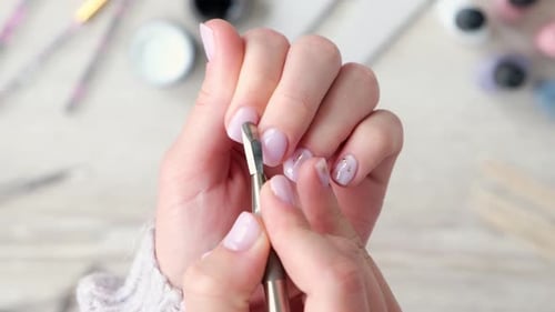 Woman Doing Manicure on Her Finger Nails