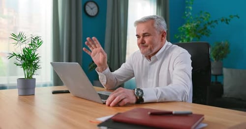 Man Video Conferencing on Laptop at Home Office