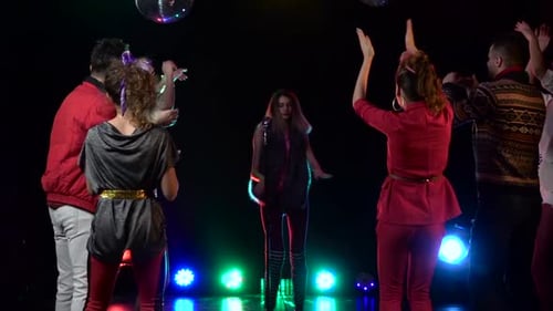 Woman Sings Karaoke as Friends Dance in Nightclub