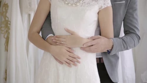 Bride and Groom Embracing in Bridal Shop