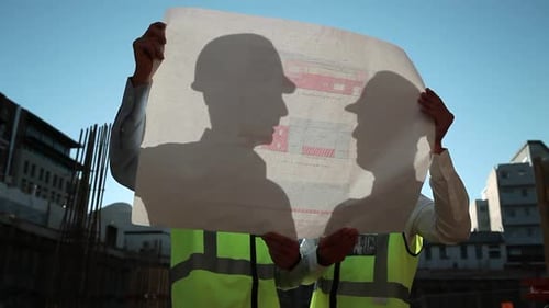 Construction Workers Reviewing Blueprints on Site