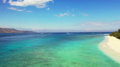Tropical fly over tourism shot of a white sand paradise beach and aqua turquoise water background in