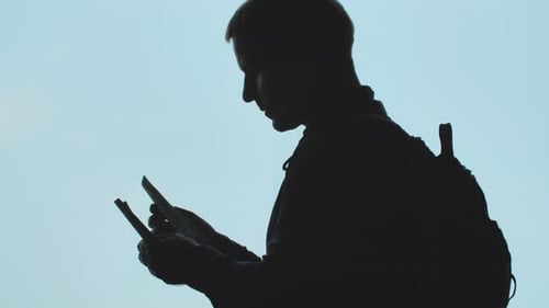 Silhouette eines jungen Mannes, der Dollar zählt, vor dem Hintergrund eines startenden Flugzeugs