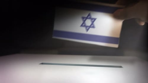 Hand Casting Vote into Ballot Box with National Flag