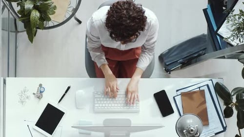 Top Down der Geschäftsfrau, die am Schreibtisch am Computer arbeitet
