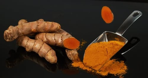 Turmeric, Turmeric Longa, Roots and Powder on Black Background, Indian Spice, Slow Motion 4K
