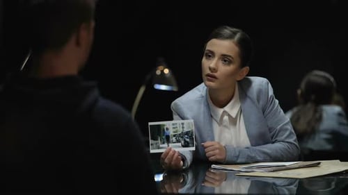 Woman Interrogating Suspect at Table