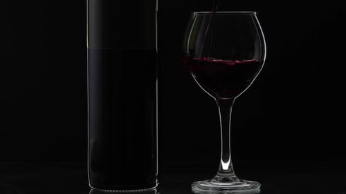 Red Wine Pouring into Glass on Black Background