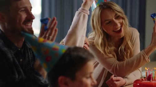 Family Celebrates Birthday with Cake and Party Horns