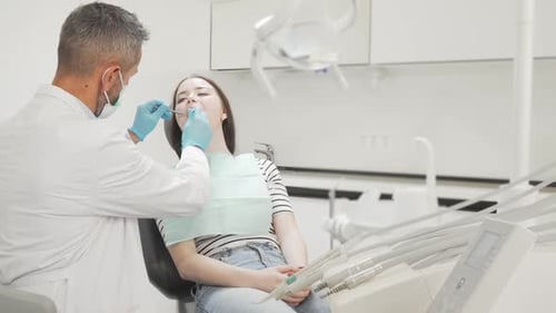 Junge Patientin lässt ihre Zähne vom Zahnarzt untersuchen