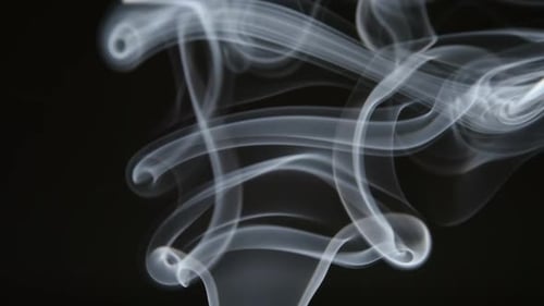 Une ligne de fumée bouclée s'élève sur un fond sombre