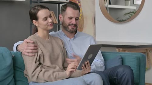 Couple Doing Video Call on Tablet While Sitting on Sofa