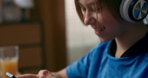 Un adolescente escucha música con auriculares inalámbricos mientras hace la tarea