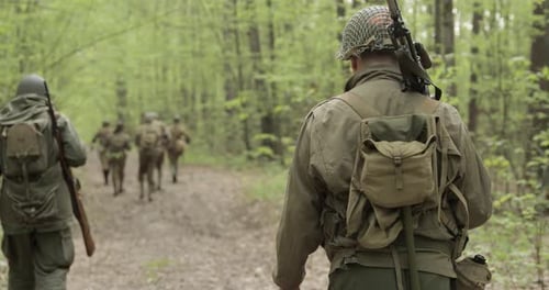 American Soldiers Of USA Infantry Of World War II Marching Walking Along Forest Road In Summer Day