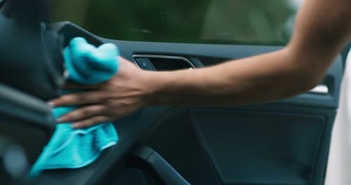 Man Cleaning Car Door Panel with Microfibre Cloth