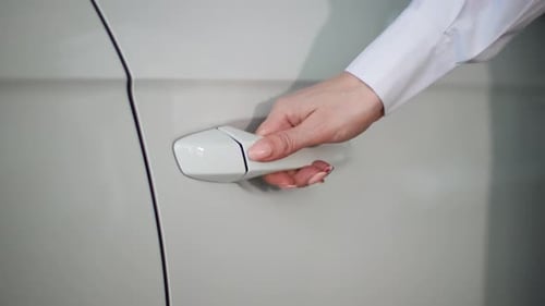 Young Female Manager Opens Car Door From Showroom to Demonstrate to Buyer Closeup