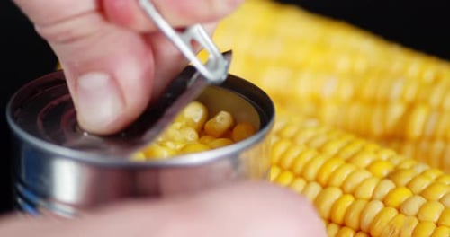 Hand Opening Can of Sweet Corn Close Up
