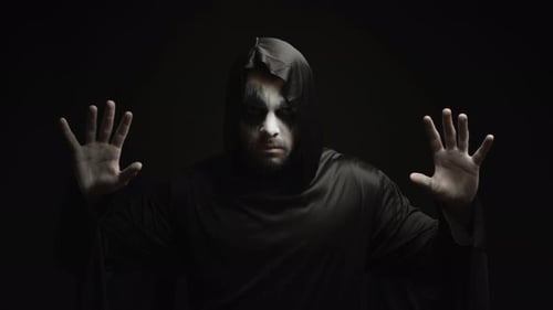 Scary Hooded Figure Raises Hands