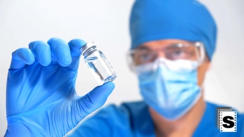 Doctor Holds Vial of Clear Liquid for Medical Purposes