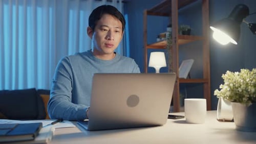 Focused Man Working on Laptop Late at Night