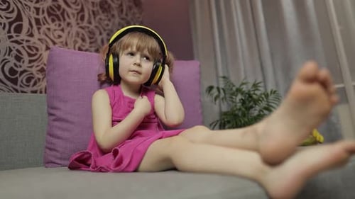 Girl Listening to Music with Headphones on Couch
