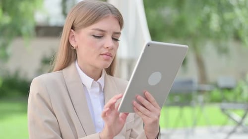 Young Woman Using Tablet Device Outdoors