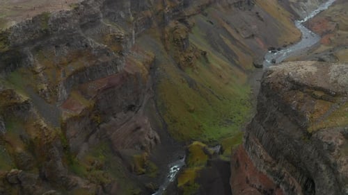 Creek Flowing in Deep Canyon with Steep Rocky Walls on Sides