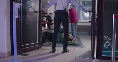 Diverse People in Masks Running Past Guard in Mall