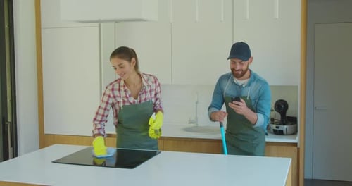 Man and Woman As a Professional Cleaners in Uniiform Having Fun During the Work on the Kitchen