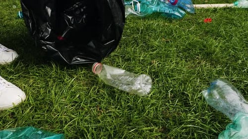 Un voluntario está limpiando el parque de botellas de plástico