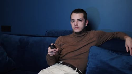 Young Adult Using TV Remote at Home