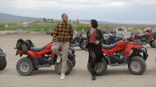 Young Couple Kissing next to ATVs