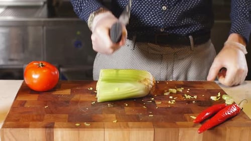 Chef Slices Fresh Celery on Butcher Block