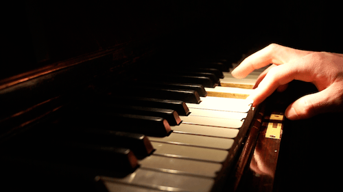 Hand Playing Piano Keyboard in the Dark