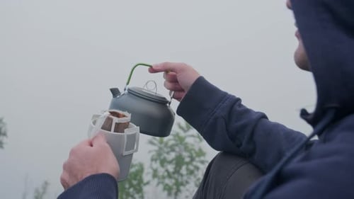 Man Brewing Coffee in Misty Forest Setting