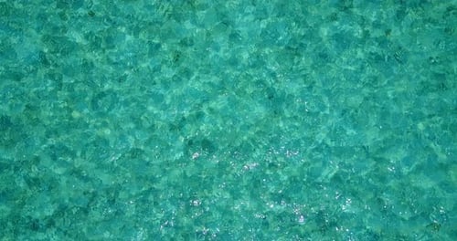 Wide birds eye tourism shot of a white sandy paradise beach and aqua turquoise water background